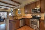 This stunning kitchen boasts beautiful wooden cabinetry and stainless steel appliances, creating a warm and inviting atmosphere.