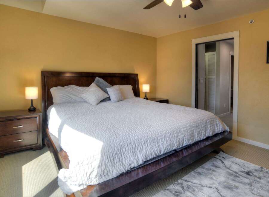 Step into this inviting bedroom, featuring a luxurious king-sized bed with a plush white comforter.