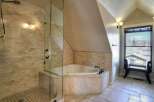 Step into luxury with this stunning bathroom featuring a corner jacuzzi tub and a separate glass-enclosed shower.