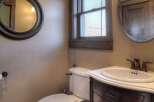 Step into this beautifully designed bathroom, featuring a classic vanity with a marble countertop and a stylish round mirror.