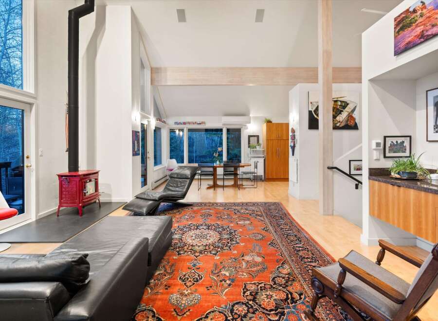 Step into luxury with this stunning property, featuring a spacious living area adorned with a vibrant Persian rug and a cozy fireplace.