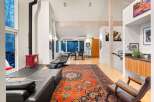 Step into luxury with this stunning property, featuring a spacious living area adorned with a vibrant Persian rug and a cozy fireplace.