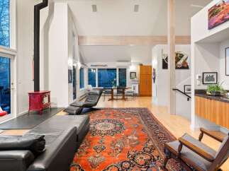 Step into luxury with this stunning property, featuring a spacious living area adorned with a vibrant Persian rug and a cozy fireplace.