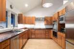 This stunning kitchen boasts custom wooden cabinetry, offering ample storage and a warm, inviting atmosphere.