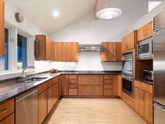 This stunning kitchen boasts custom wooden cabinetry, offering ample storage and a warm, inviting atmosphere.