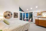 This stunning bedroom boasts a unique blend of art and natural light, creating a serene and inviting atmosphere.