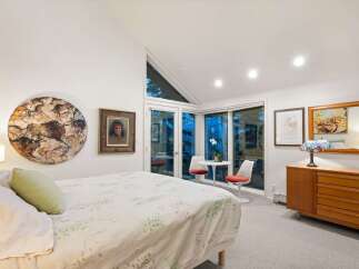 This stunning bedroom boasts a unique blend of art and natural light, creating a serene and inviting atmosphere.