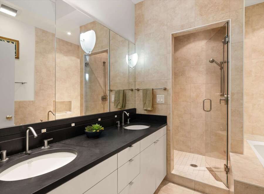 Step into luxury with this stunning bathroom featuring a sleek black countertop and dual sinks.