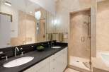 Step into luxury with this stunning bathroom featuring a sleek black countertop and dual sinks.