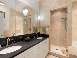 Step into luxury with this stunning bathroom featuring a sleek black countertop and dual sinks.