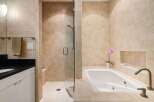 Step into luxury with this stunning bathroom featuring a sleek shower and a relaxing bathtub.