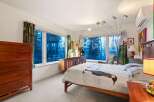 This stunning bedroom boasts a serene ambiance with its large windows offering picturesque views.