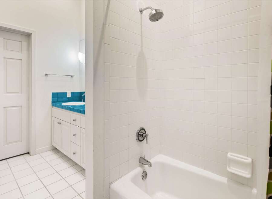 Step into this bright and inviting bathroom, featuring a pristine white tile design.
