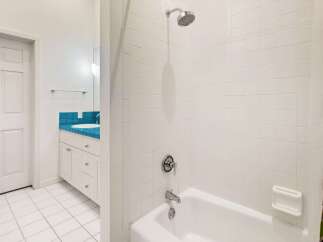 Step into this bright and inviting bathroom, featuring a pristine white tile design.