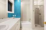 This modern bathroom features a sleek design with a combination of white and blue tiles, creating a refreshing and stylish atmosphere.