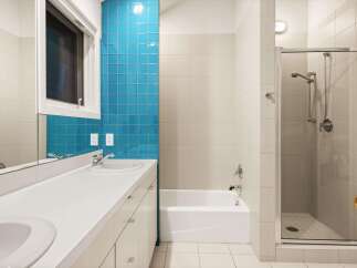 This modern bathroom features a sleek design with a combination of white and blue tiles, creating a refreshing and stylish atmosphere.