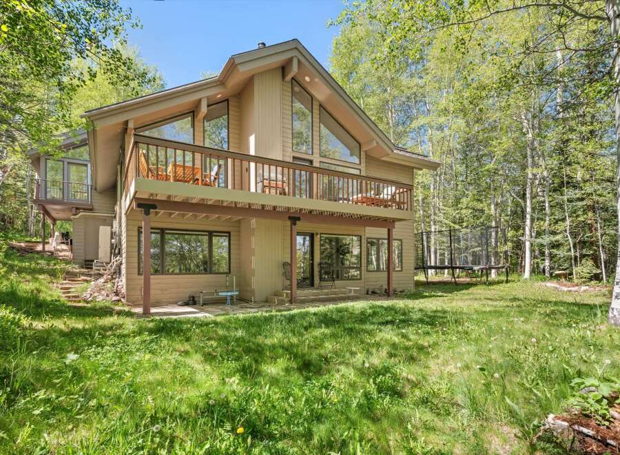 Nestled amidst lush greenery and tall trees, this charming home offers a serene retreat.