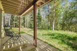 Enjoy the serene mountain setting from this covered patio, perfect for relaxing amidst the tall trees.