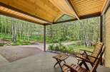 Enjoy the serene mountain setting from this charming covered porch, perfect for relaxing amidst the aspen trees.