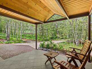 Enjoy the serene mountain setting from this charming covered porch, perfect for relaxing amidst the aspen trees.