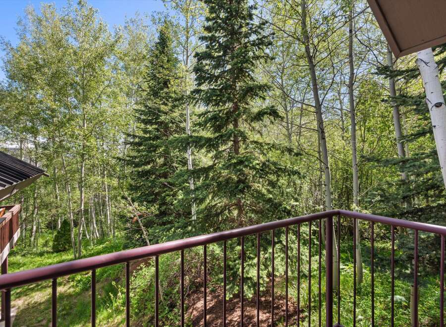 Enjoy the serene mountain views from this private balcony, surrounded by lush aspen and pine trees.