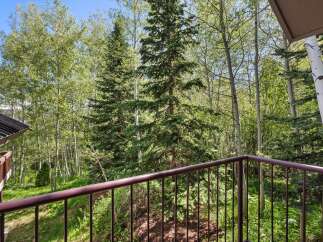 Enjoy the serene mountain views from this private balcony, surrounded by lush aspen and pine trees.