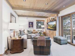Step into luxury with this stunning living room, featuring a cozy seating area and a built-in entertainment center.