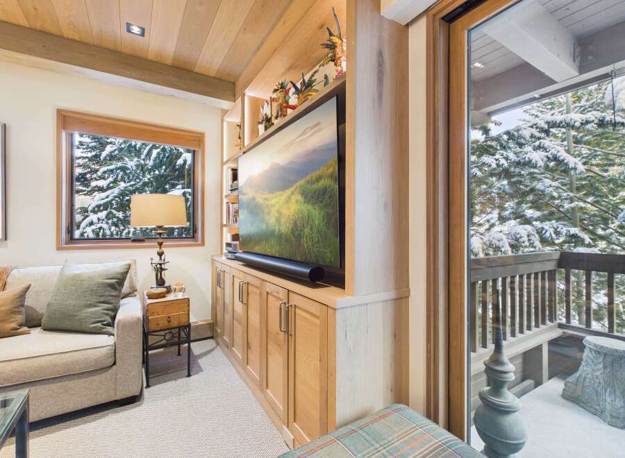 This cozy living space features a built-in entertainment center with a large flat-screen TV and ample storage.