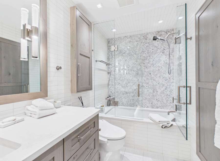 This modern bathroom boasts a sleek design with a glass-enclosed shower and a luxurious soaking tub.