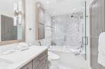 This modern bathroom boasts a sleek design with a glass-enclosed shower and a luxurious soaking tub.