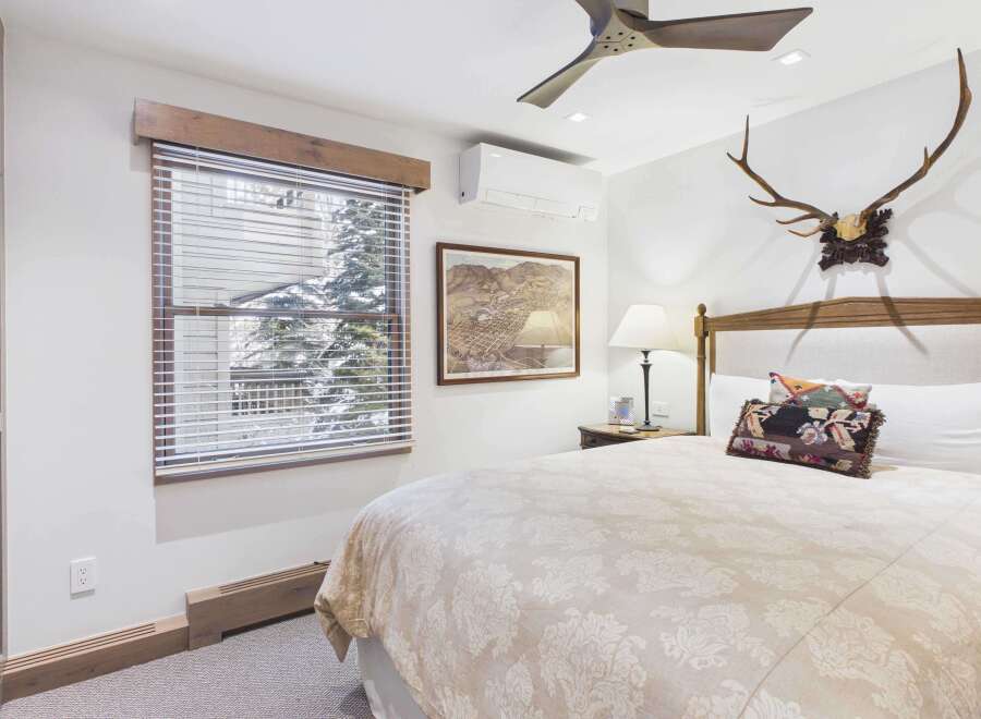 This cozy bedroom features a comfortable bed with decorative pillows and a beautiful floral patterned comforter.
