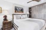 This bedroom offers a serene retreat with its neutral color palette and elegant furnishings.