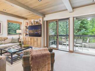 Experience luxurious living in this beautifully appointed living room, featuring a spacious sectional sofa and a stylish glass-top coffee table perfect for entertaining.
