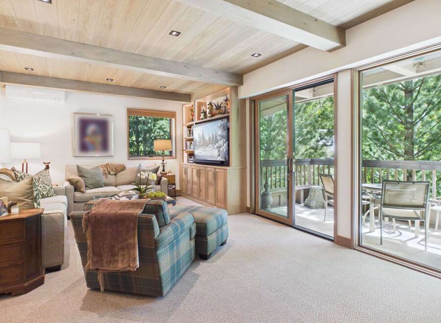 Experience mountain living in this beautifully appointed living room, featuring a cozy fireplace, plush seating, and a large TV for entertainment.