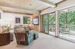 Experience mountain living in this beautifully appointed living room, featuring a cozy fireplace, plush seating, and a large TV for entertainment.