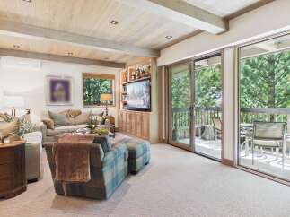 Experience mountain living in this beautifully appointed living room, featuring a cozy fireplace, plush seating, and a large TV for entertainment.