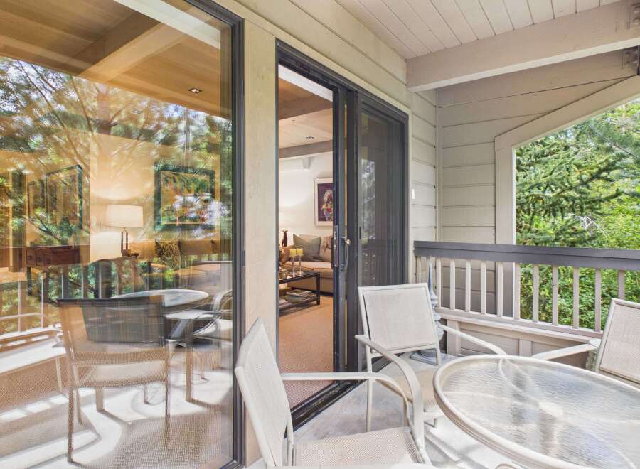 Enjoy indoor-outdoor living with this spacious balcony featuring comfortable seating and a glass-top table, perfect for morning coffee or evening relaxation.