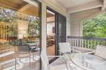 Enjoy indoor-outdoor living with this spacious balcony featuring comfortable seating and a glass-top table, perfect for morning coffee or evening relaxation.