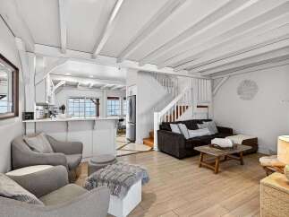 Discover the charm of this beautifully designed home, featuring a bright and airy living space with exposed beams and a cozy fireplace.