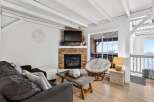 Discover the charm of this cozy living space, featuring a stunning stone fireplace and a comfortable seating area.