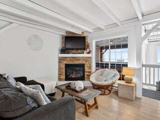 Discover the charm of this cozy living space, featuring a stunning stone fireplace and a comfortable seating area.