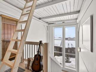 This charming property features a cozy loft space accessible by a rustic wooden ladder, perfect for a home office or guest area.