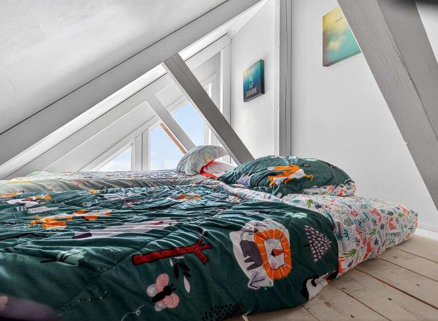 This charming attic bedroom offers a cozy and inviting space.