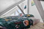 This charming attic bedroom offers a cozy and inviting space.