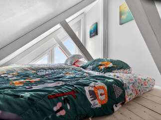 This charming attic bedroom offers a cozy and inviting space.