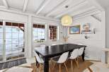 This charming dining room features a rustic aesthetic with a dark wood dining table and stylish white chairs.
