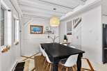 This charming dining room features a stylish black dining table and modern white chairs, perfect for hosting gatherings.