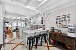 This stunning kitchen boasts a bright and airy design with exposed beams and a modern aesthetic.