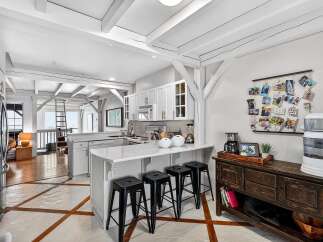 This stunning kitchen boasts a bright and airy design with exposed beams and a modern aesthetic.