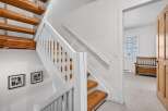 This stunning property features a beautifully crafted staircase with wooden steps and white railings, creating a warm and inviting atmosphere.